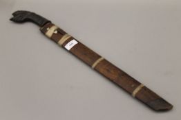 A Javanese Wedung knife with carved head horn handle and wooden sheath. 62 cm long.