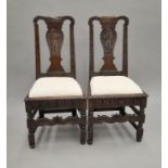 A pair of Georgian carved oak chairs. 47 cm wide.