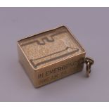 A 9 ct gold charm with enclosed bank note. 1 cm high. 2.7 grammes total weight.