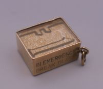 A 9 ct gold charm with enclosed bank note. 1 cm high. 2.7 grammes total weight.