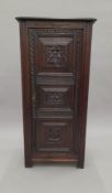 A 19th century carved oak cupboard. 55 cm wide.