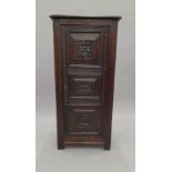 A 19th century carved oak cupboard. 55 cm wide.