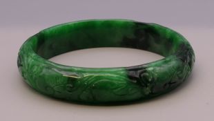 A carved jade bangle. 6 cm inner diameter.