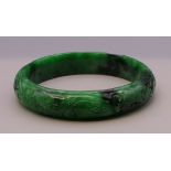 A carved jade bangle. 6 cm inner diameter.