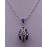 An enamel decorated silver egg form pendant on chain. The pendant 3 cm high.