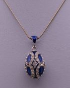 An enamel decorated silver egg form pendant on chain. The pendant 3 cm high.