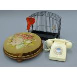 A Victorian stool, a vintage bird cage and a white telephone.