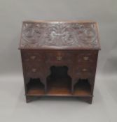 A Victorian carved oak bureau. 90.5 cm wide.