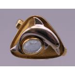 An 18 ct gold aquamarine dolphin form ring. Ring size N. 5.9 grammes total weight.
