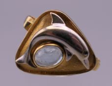 An 18 ct gold aquamarine dolphin form ring. Ring size N. 5.9 grammes total weight.