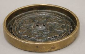 A small Chinese bronze mirror. 10 cm diameter.