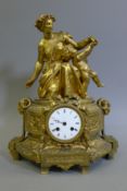 A 19th century gilt mantle clock surmounted with a woman and a putto. 41 cm high.