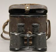 A cased pair of 1942 German binoculars. The case 15.5 cm high.