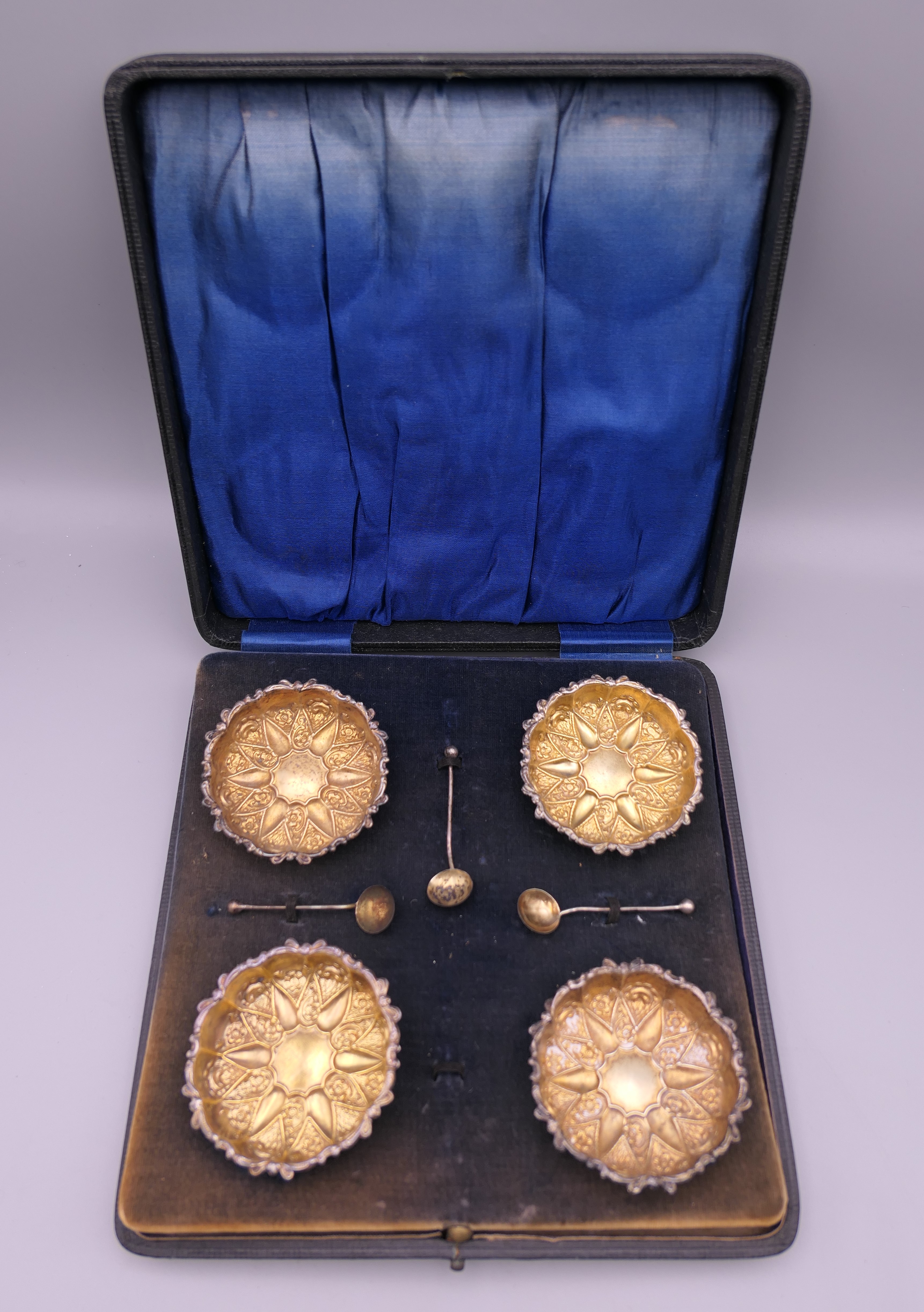 A cased set of four silver gilt salts. Each 6 cm diameter.