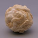 A bone carving formed as mermaids. 3 cm diameter.