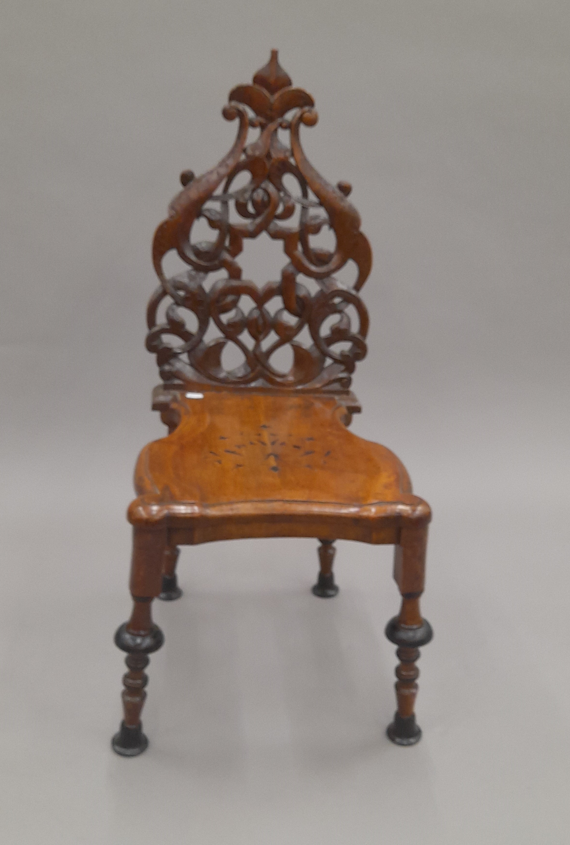 A 19th century carved hall chair. 39 cm wide.