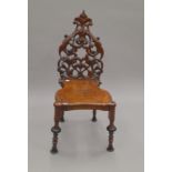 A 19th century carved hall chair. 39 cm wide.