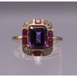 An Art Deco style 9 ct gold amethyst, ruby and diamond ring. Ring size O.