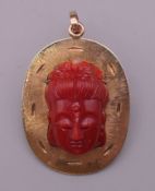 A 14 K gold and coral brooch/pendant. 4.5 cm high. 13 grammes total weight.