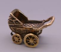 A 9 ct gold charm formed as a pram. 4.4 grammes.