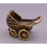 A 9 ct gold charm formed as a pram. 4.4 grammes.