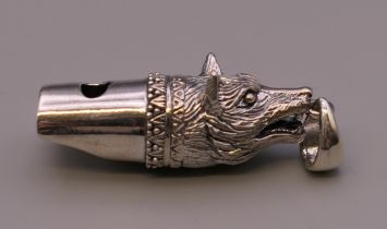 A silver whistle formed as a fox. 4.5 cm long.