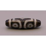 A gold inlaid dzi bead. 4 cm long.