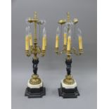 A pair of bronze cherub form lamps. 71 cm high overall.