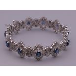 A 14 ct white gold diamond and sapphire bracelet. 18.5 cm long. 32.8 grammes total weight.