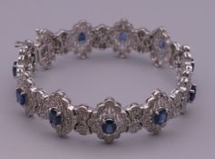 A 14 ct white gold diamond and sapphire bracelet. 18.5 cm long. 32.8 grammes total weight.