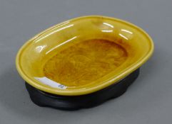 An Oriental yellow porcelain dish, with stand. 11.5 cm long.