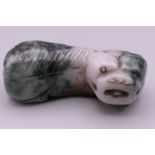 A Chinese russet green jade toggle in the form of a recumbent dog of fo. 4.5 cm long.