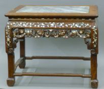 A 19th century Chinese mother-of-pearl inlaid marble topped low table (adapted from a chair). 62.
