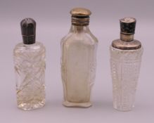 Three silver top scent bottles. Largest 9.5 cm high.