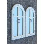 A pair of white arched shutter mirrors. 101 cm high.