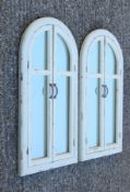 A pair of white arched shutter mirrors. 101 cm high.