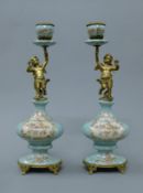 A pair of cherub mounted porcelain candlesticks. 36 cm high.