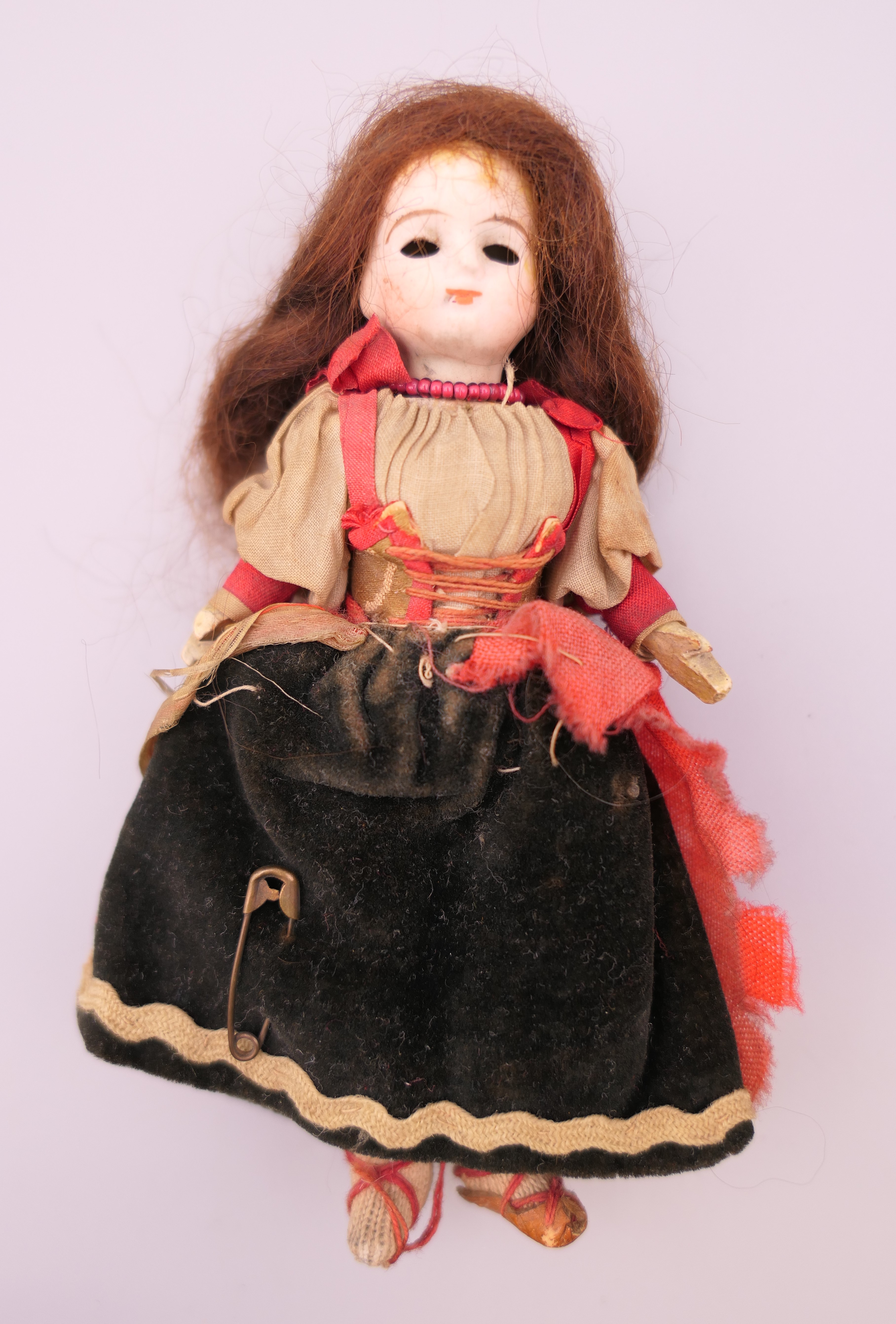 A 19th century miniature bisque headed doll. 13 cm high.