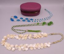 A jewellery box containing three necklaces. Blue and clear bead necklace approximately 72 cm long.