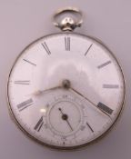 A silver pocket watch. Approximately 4.5 cm diameter.