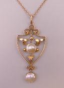 An Arts and Crafts 9 ct gold pearl drop pendant on a gold chain. Pendant 4.