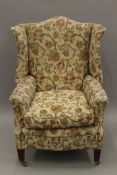 A late 19th/early 20th century upholstered wing back arm chair. 74 cm wide.