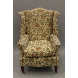 A late 19th/early 20th century upholstered wing back arm chair. 74 cm wide.