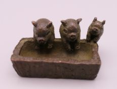 A small bronze model of pigs at a trough. 4.5 cm long.