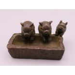 A small bronze model of pigs at a trough. 4.5 cm long.