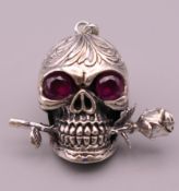 A skull and rose pendant. 2.5 cm high.