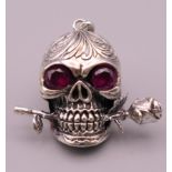 A skull and rose pendant. 2.5 cm high.