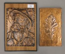 Two vintage copper plaques, one formed as a man smoking a pipe mounted on a wooden board.