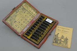 A Chinese abacus in a lacquered box. The box 20 cm wide.