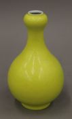 A Chinese porcelain lemon yellow glazed onion neck vase incised all over with dragon waves, clouds,